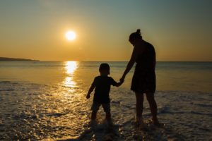 Fördere ich mein Kind genug? - Mama mit Kind am Strand